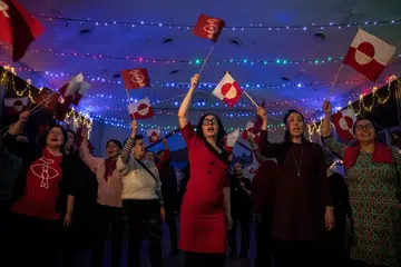 Penyokong parti pemerintah Inuit Ataqatigiit memberikan reaksi semasa pilihan raya umum di Nuuk, Greenland, pada 11 Mac 2025.