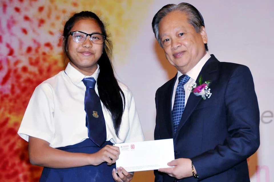 BERI SEMANGAT BARU: Dermasiswa yang diterima pelajar Sekolah Menengah Juying, Nur Sri Sabrina Abdullah pastinya akan memberi semangat baru untuknya belajar dengan lebih bersungguh-sungguh lagi. Menyampaikan anugerah itu ialah Encik Roger Tham, Penolong Setiausaha Agung MDIS. - Foto MDIS