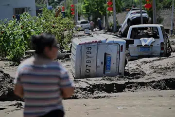 Seorang lelaki melihat kereta-kereta yang rosak akibat banjir susulan hujan lebat sejak beberapa hari lalu di daerah Huairou, pinggir bandar Beijing pada 30 Julai 2025. Hujan lebat telah meragut lebih 30 nyawa dan memaksa pihak berkuasa memindahkan puluhan ribu penduduk apabila wilayah utara China dilanda hujan mencurah-curah yang mencetuskan tanah runtuh dan banjir, menurut media rasmi pada 29 Julai. 