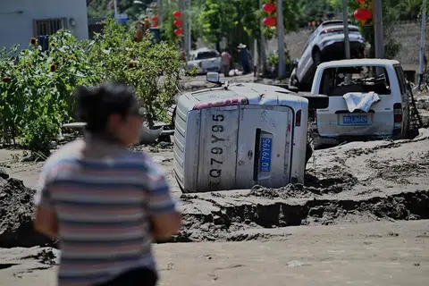 Seorang lelaki melihat kereta-kereta yang rosak akibat banjir susulan hujan lebat sejak beberapa hari lalu di daerah Huairou, pinggir bandar Beijing pada 30 Julai 2025. Hujan lebat telah meragut lebih 30 nyawa dan memaksa pihak berkuasa memindahkan puluhan ribu penduduk apabila wilayah utara China dilanda hujan mencurah-curah yang mencetuskan tanah runtuh dan banjir, menurut media rasmi pada 29 Julai. 