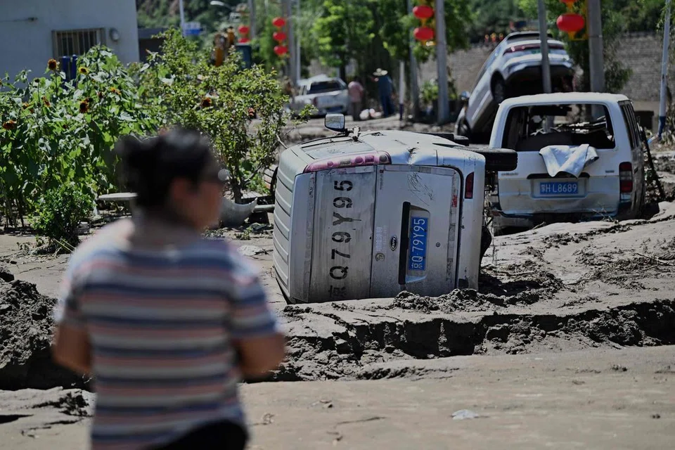 Seorang lelaki melihat kereta-kereta yang rosak akibat banjir susulan hujan lebat sejak beberapa hari lalu di daerah Huairou, pinggir bandar Beijing pada 30 Julai 2025. Hujan lebat telah meragut lebih 30 nyawa dan memaksa pihak berkuasa memindahkan puluhan ribu penduduk apabila wilayah utara China dilanda hujan mencurah-curah yang mencetuskan tanah runtuh dan banjir, menurut media rasmi pada 29 Julai. 