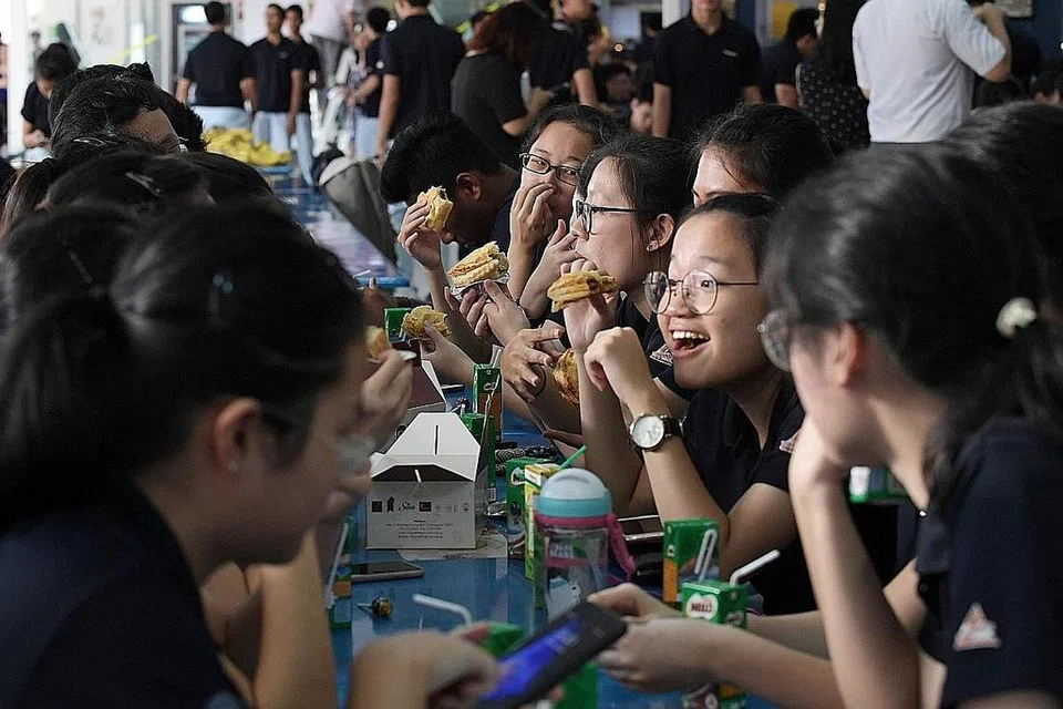 SARAPAN PAGI BERSAMA: Pelajar TMJC bersarapan pagi bersama semalam. Makanan seperti pastri, biskut dan buah-buahan serta air kotak disediakan oleh pihak sekolah. - Foto BH oleh ALPHONSUS CHERN