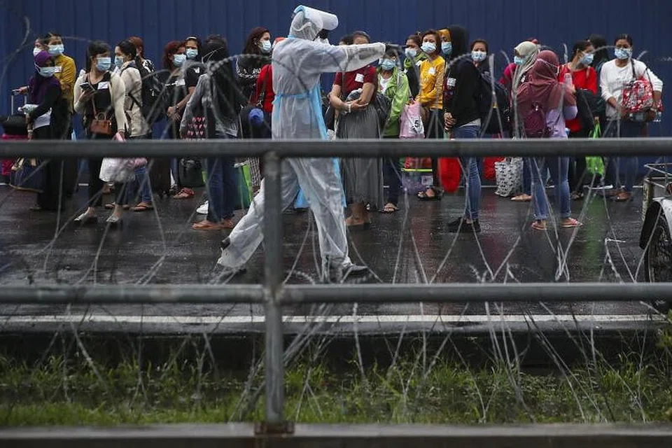 Pekerja kilang Top Glove menunggu giliran dibawa ke hospital berdekatan kilang tersebut di Shah Alam. - Foto EPA