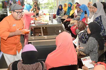 SAMBUTAN MENGGALAKKAN: Peserta tunjuk cara memasak anjuran Harvey Norman dan Berita Harian begitu tekun mendengar penerangan Cef Mel mengenai bahan masakan sajian Mexico yang beliau ajar. - Foto JOHARI RAHMAT