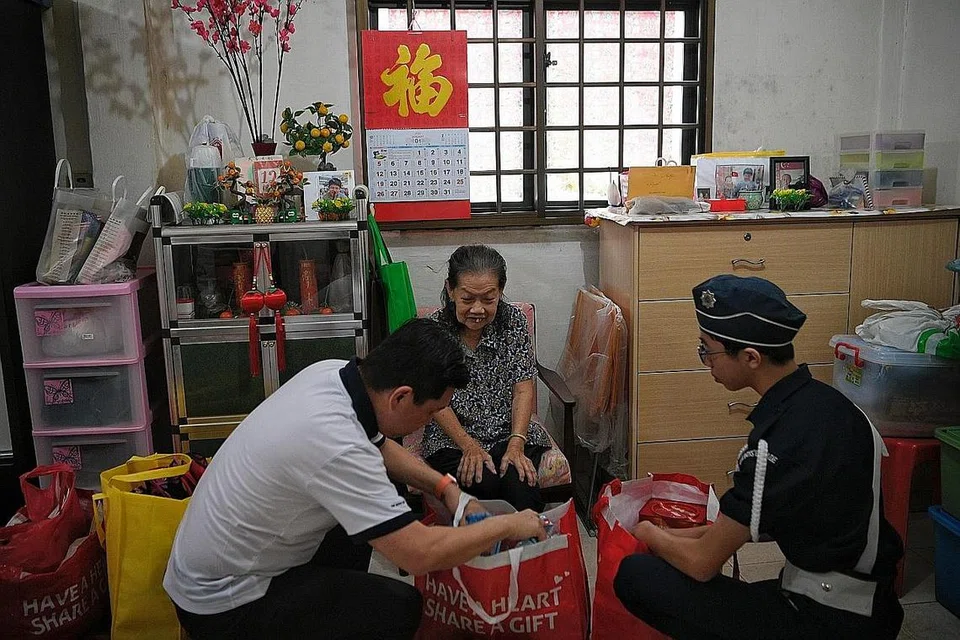 DEKATI GOLONGAN MEMERLUKAN: Anggota Boys' Brigade, Matthew Ong (kanan) dari Sekolah Fairfield Methodist dan Encik Henry Tan (kiri) menghantar hamper makanan kepada benefisiari di kawasan Redhill semalam. - Foto BH oleh MARK CHEONG