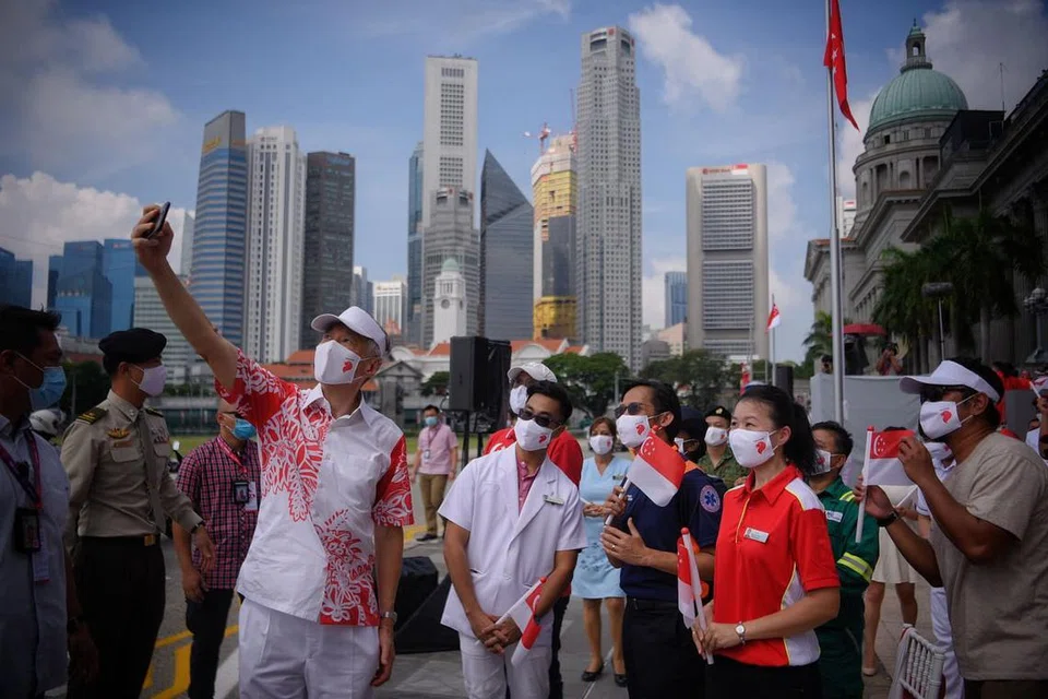 PERJUANGAN TERHADAP COVID-19: Dalam Perbarisan Hari Kebangsaan yang lalu, Perdana Menteri Lee Hsien Loong bergambar bersama pekerja yang berada di barisan depan dalam usaha memerangi Covid-19. Dalam Amanat Tahun Barunya, Encik Lee berkata Covid-19 merupakan satu perjuangan tidak henti-henti yang telah menguji sepenuhnya sumber-sumber dan keazaman Singapura. - Foto fail