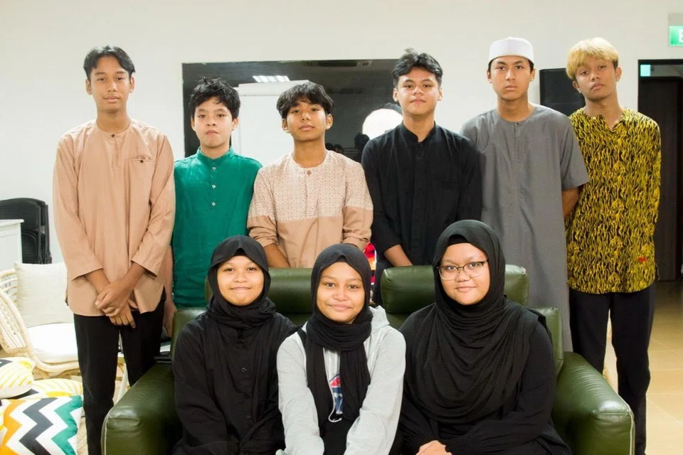 TIMBA ILMU AGAMA:  Pelajar Adam Ashar Mujahid ((dua dari kiri, barisan belakang) seronok dapat bersama abangnya, Mohd Haydar Genelo Mujahid (tiga dari kanan, barisan belakang), bersama rakan lain di kelas Program Sijil Pengajian Islam Remaja.