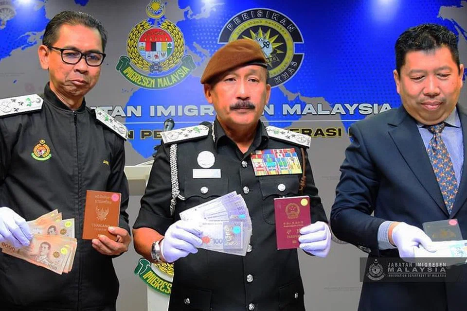 Ketua Pengarah Imigresen Malaysia, Datuk Ruslin Jusoh (tengah), menunjukkan barangan yang dirampas selepas menumpaskan sindiket ejen haram dalam operasi khas Bahagian Perisikan dan Operasi Khas Jabatan Imigresen Putrajaya.