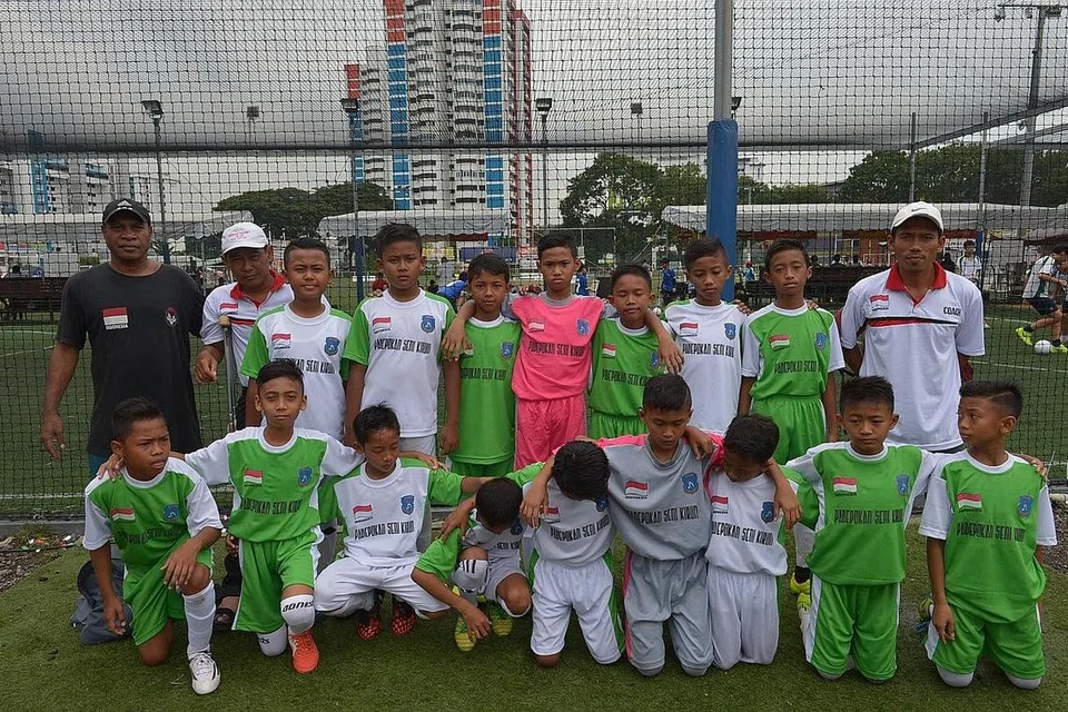 GEMBIRA DAPAT KE SINGAPURA: Encik Surawan (belakang kanan) berkata bahawa pasukannya, Asosiasi Sepak Bola Indoensia Jawa Timur, atau ASSBI Jatim, amat gembira diberi peluang bermain di Singapura.