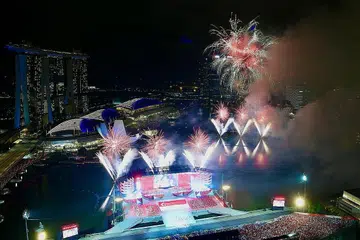 GEMERLAPAN CAHAYA: Lautan merah dan putih warga menyaksikan Perbarisan Hari Kebangsaan (NDP) tahun ini di Pentas Terapung Marina Bay. - Foto-foto BH oleh DESMOND FOO, LIM YAOHUI