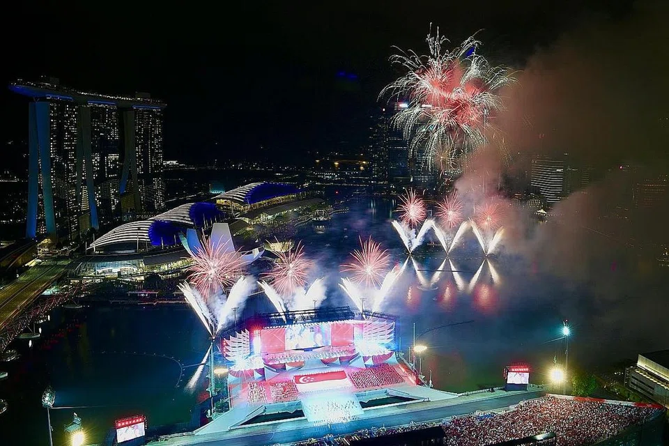 GEMERLAPAN CAHAYA: Lautan merah dan putih warga menyaksikan Perbarisan Hari Kebangsaan (NDP) tahun ini di Pentas Terapung Marina Bay. - Foto-foto BH oleh DESMOND FOO, LIM YAOHUI