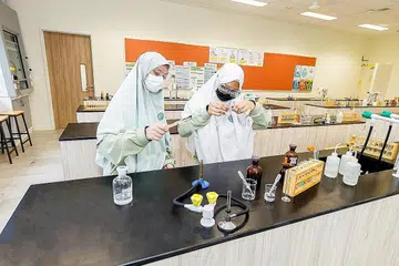 CEMERLANG DALAM SAINS: Dua di antara pelajar Madrasah Al-Arabiah Al-Islamiah yang cemerlang dalam pelajaran sains dan sedang mengikuti program tahunan, Program Kajian Belia di A*STAR, Mishel Maryam Nasir (kiri) dan Kashfia Humaira Shahjahan. - Foto MADRASAH AL-ARABIAH AL-ISLAMIAH (MAI)