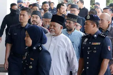 Ketua Pegawai Eksekutif (CEO) kumpulan perniagaan, Global Ikhwan Service and Business Holdings (GISBH), Nasiruddin Mohd Ali (berbaju putih, dua dari kanan) dan 21 yang lain dibawa ke Mahkamah Sesyen Selayang, Selangor, pada 23 Oktober lalu kerana didakwa menjadi ahli kumpulan jenayah terancang.
