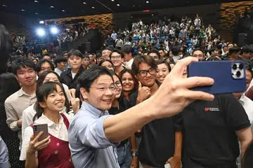Perdana Menteri, Encik Lawrence Wong, mengambil ‘wefie’ bersama sekumpulan pelajar selepas sesi dialog  di Universiti Pengurusan Singapura (SMU) pada 2 Julai 2024.