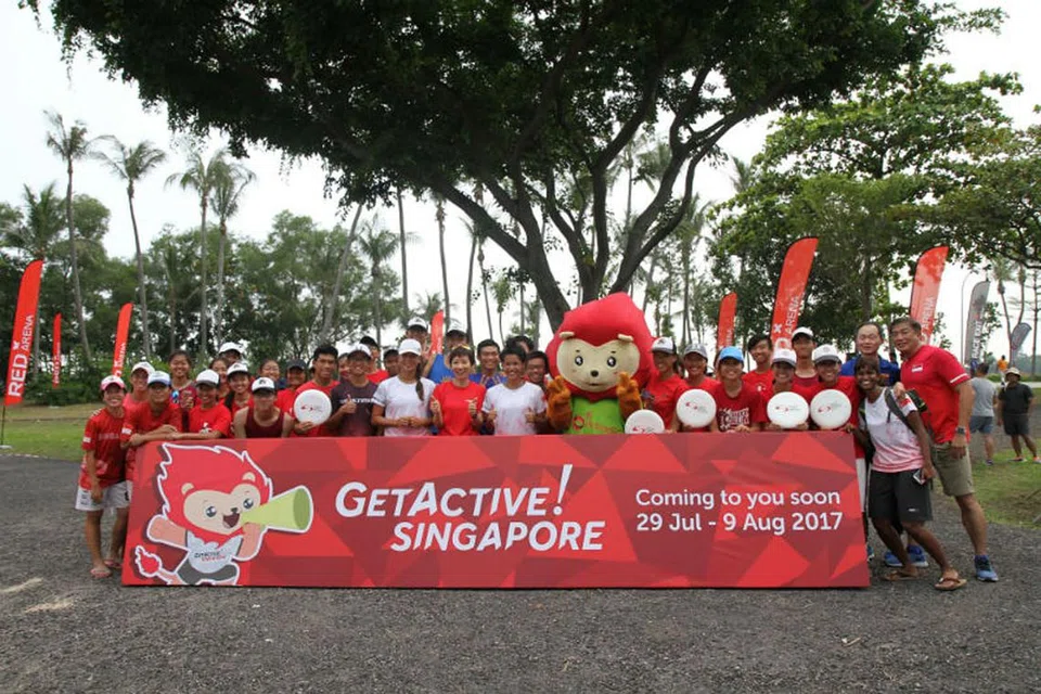 MINGGU AKTIF: Menteri Kebudayaan, Masyarakat dan Belia, Cik Grace Fu (tengah, berbaju merah), bersama-sama maskot Nila dan penggemar permainan frisbee memguar-uarkan inisiatif GetAktive! Singapore. - Foto SPORTSG