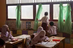 Seorang murid melihat ke luar tingkap bilik darjah sebelum dibenarkan pulang awal susulan asap tebal akibat kebakaran tanah di belakang sekolahnya di Kampung Alalak, daerah Barito Kuala, Kalimantan Selatan, pada 28 Oktober 2026. Kebakaran hutan dan tanah gambut yang berlarutan di Indonesia menjejas pembelajaran kira-kira 1.4 juta pelajar, dengan ribuan sekolah terpaksa beralih kepada pembelajaran dalam talian, manakala peperiksaan penting di beberapa kawasan ditangguhkan.