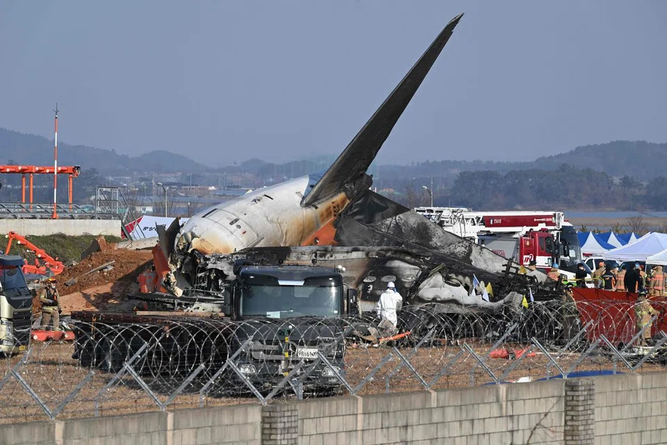 Pasukan bomba dan penyelamat berhampiran serpihan pesawat Jeju Air Boeing 737-800 yang terhempas dan terbakar di Lapangan Terbang Antarabangsa Muan, di Wilayah Jeolla Selatan, kira-kira 288 kilometer ke barat daya Seoul, pada 29 Disember 2024. 