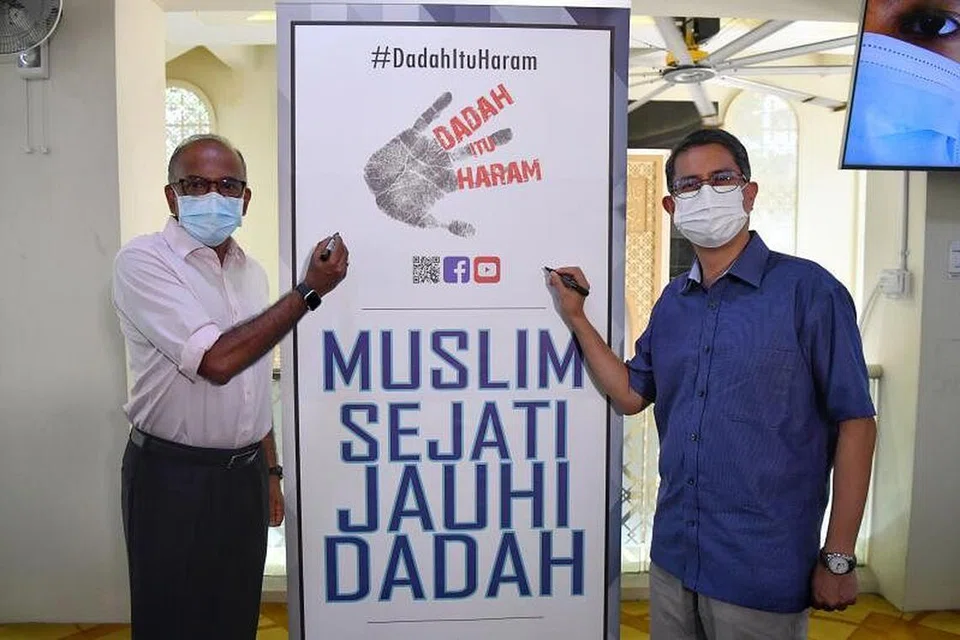 ALU-ALUKAN SOKONGAN MASJID: Encik K. Shanmugam (kiri) dan Profesor Madya Muhammad Faishal Ibrahim menandatangani kain rentang di majlis pelancaran Dadah Itu Haram 2021 di Masjid Al-Ansar. - Foto BH oleh CHONG JUN LIANG 