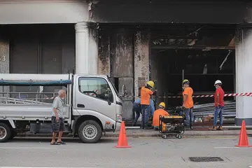 TAPAK KEMALANGAN: Sekumpulan pekerja kelihatan sedang memasang palang untuk menutup tapak kemalangan di Tanjong Pagar, di mana lima pemuda terkorban setelah kereta yang mereka naiki merempuh sebuah rumah kedai lalu terbakar. - Foto BH oleh GIN TAY