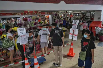 LANGKAH DIPERTINGKAT: Pengunjung ke pasar dan pusat penjaja, seperti di Pasar dan Pusat Penjaja Kovan 209 perlu menggunakan TraceTogether. - Foto BH oleh KEVIN LIM