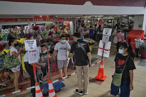 LANGKAH DIPERTINGKAT: Pengunjung ke pasar dan pusat penjaja, seperti di Pasar dan Pusat Penjaja Kovan 209 perlu menggunakan TraceTogether. - Foto BH oleh KEVIN LIM