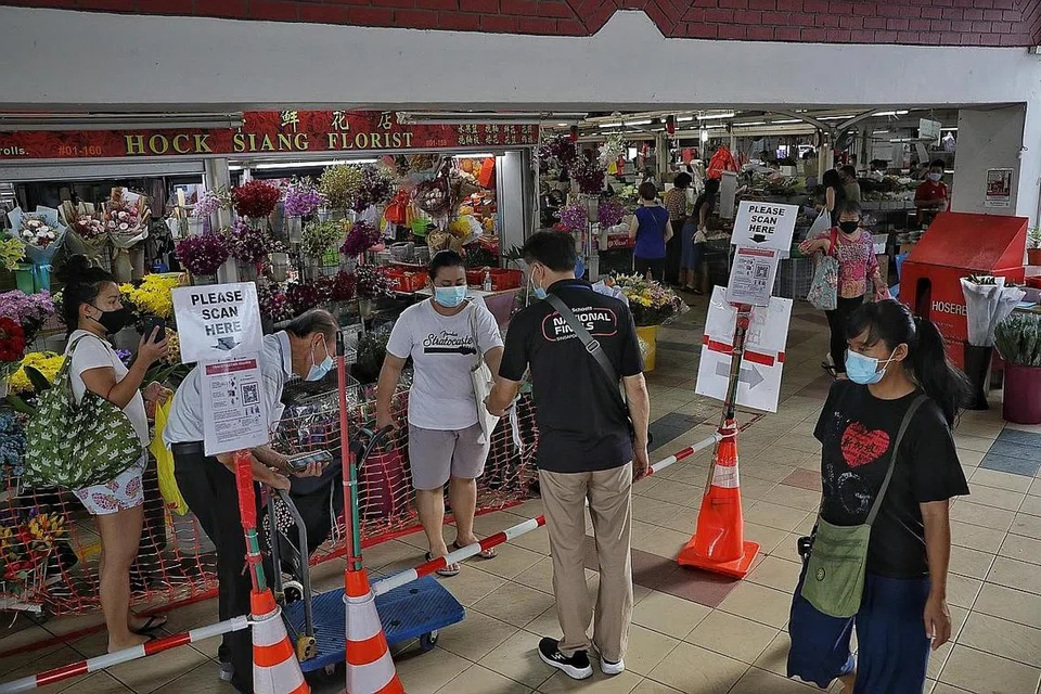 LANGKAH DIPERTINGKAT: Pengunjung ke pasar dan pusat penjaja, seperti di Pasar dan Pusat Penjaja Kovan 209 perlu menggunakan TraceTogether. - Foto BH oleh KEVIN LIM