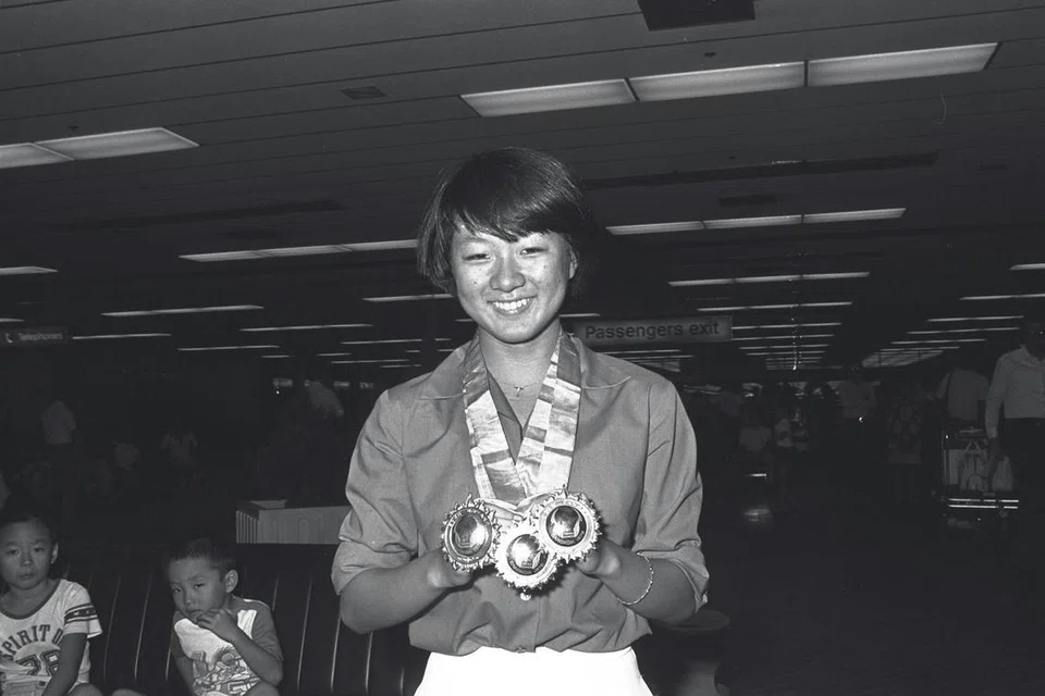 Perenang Junie Sng mempamerkan dua pingat emas dan satu pingat perak yang dimenanginya semasa Sukan Asia dengan bangga. 