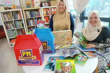 PEMANGKIN BUDAYA MEMBACA: Cik Hanisnah (duduk) dan Cik Haryani melakar program bagi membantu golongan buta huruf dan sukar membaca di pusat literasi mereka di Jalan Pemimpin dekat Upper Thomson Road. - Foto BH oleh SAINI SALLEH