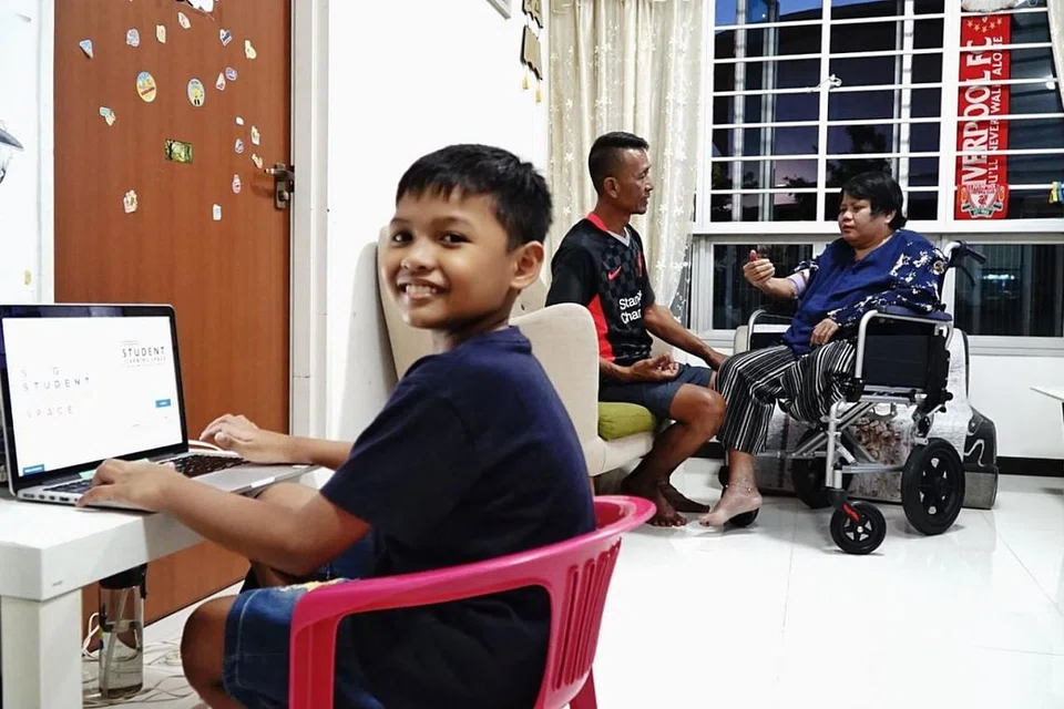 MENARIK NAFAS LEGA: Dengan Anugerah HomeTeamNS Pendidikan Kanak-kanak (CEA), Encik Adnan (tengah) dapat menarik nafas lega dengan wang tunai dan baucar yang dapat membiayai keperluan sekolah Danial (kiri) serta kos perubatan isterinya, Cik Fiterawati (kanan). - Foto BH oleh KHALID BABA