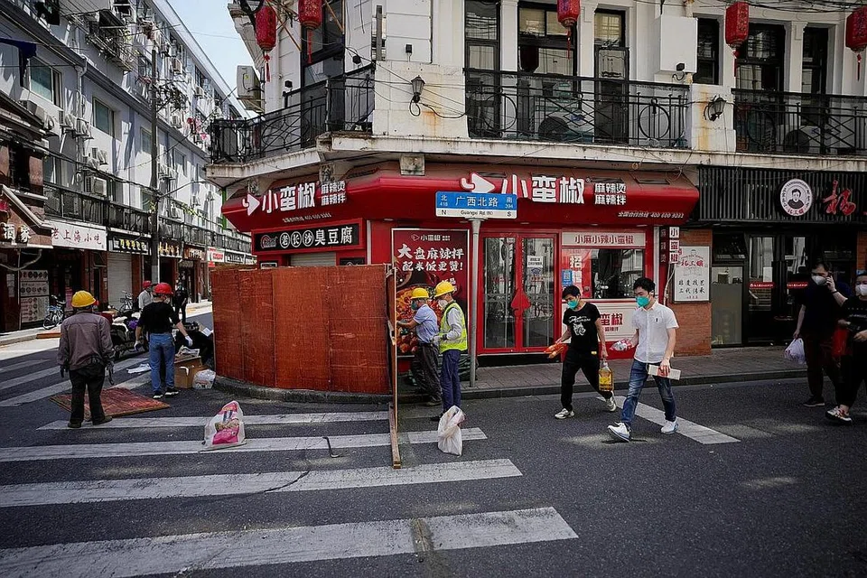 DITANGGALKAN: Sekatan pagar yang mengelilingi kawasan perumahan di Shanghai telah mula ditanggalkan menjelang langkah menarik balik sekatan ketat di bandar itu mulai hari ini. - Foto REUTERS