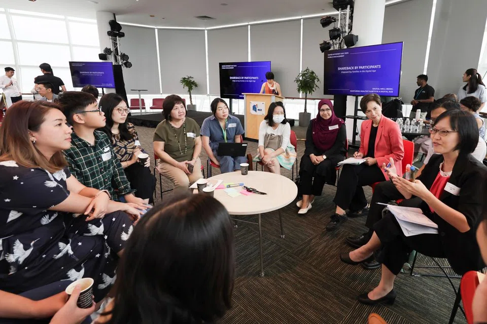 Menteri Perhubungan dan Penerangan, Cik Josephine Teo (jaket merah), sertai peserta berbincang cara pertingkat kesejahteraan digital pada 13 Februari 2024, sebagai menyokong Hari Internet Selamat 2024.