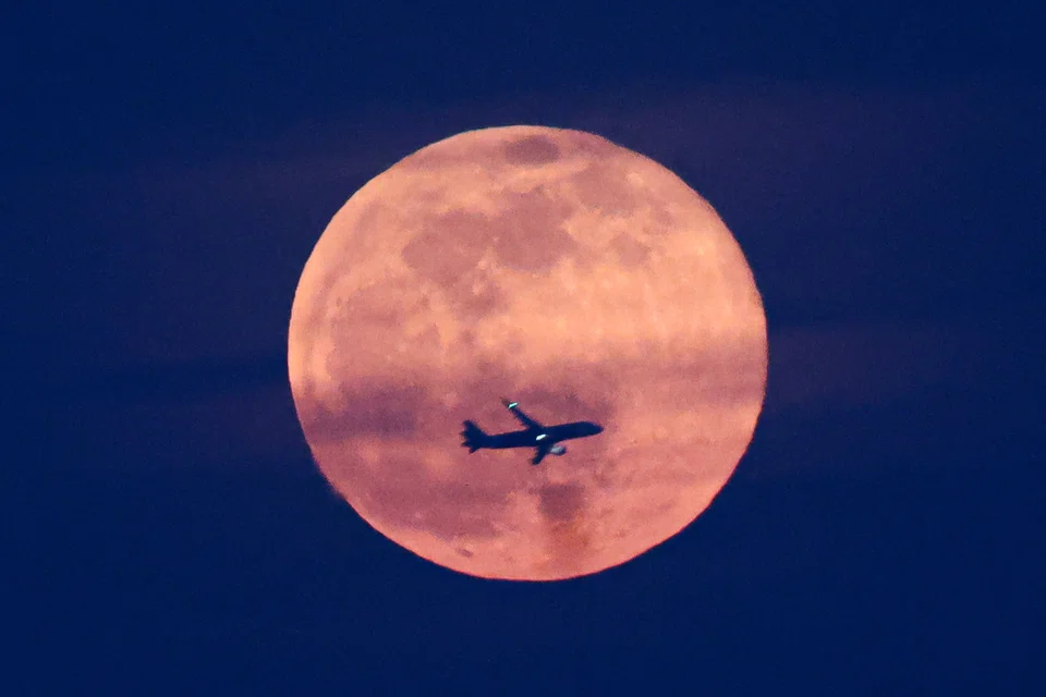 SINAR PURNAMA: Gambar ‘Harvest Moon’ yang memancarkan cahaya jingga terang, diambil di Gardens by the Bay, pada 7 Oktober.