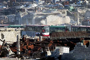 OPERASI PINDAHKAN PENDUDUK ALEPPO: Bas-bas ini melalui bandar Ramoussa, di selatan Aleppo, semasa proses pemindahan penduduk daripada wilayah yang dikawal pemberontak. - Foto AFP