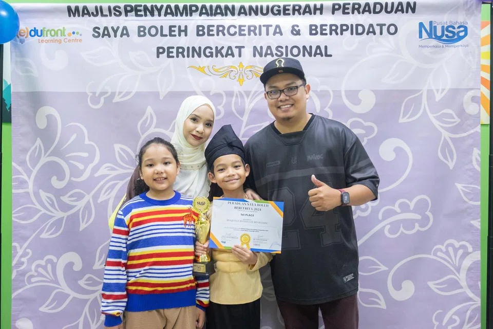 Johan Kategori B ‘Saya Boleh Bercerita’, Shaquille Mateen Lee Ruzaini (dua dari kanan), bergambar bersama (dari kanan) ayahnya, Encik Ruzaini Raaziq Lee; ibunya, Cik Hur Zaimah Fadlon; dan adiknya, Adeena Imaani Ruzaini.