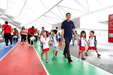 ACARA KEMASYARAKATAN: Dr Maliki bersama kanak-kanak prasekolah menyertai acara kemasyarakatan yang mengumpul dana bagi penduduk susah. Ia merupakan antara acara anjuran CDC South East tahun lalu demi membantu warga susah. - Foto fail
