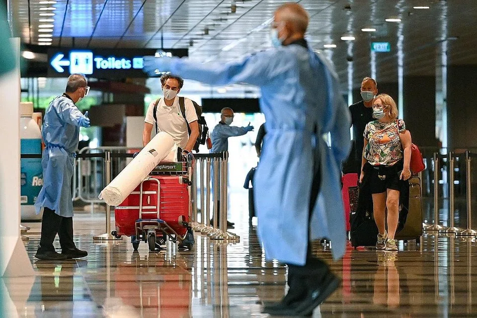 SELAMAT DATANG: Beberapa pekerja di Lapangan Terbang Changi kelihatan menyambut ketibaan penumpang pesawat SQ329, dari Amsterdam, Belanda pada Rabu lalu. Kira-kira 250 penumpang mendarat di lapangan terbang itu dalam dua pesawat pertama di bawah skim Laluan Perjalanan bagi Orang yang Divaksin (VTL). - Foto BM oleh LIM YAOHUI