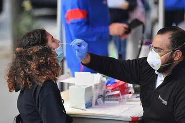 JALANI UJIAN: Seorang pekerja perubatan sedang melakukan pemeriksaan hidung ke atas seorang pelajar bagi pengesanan Covid-19 di pusat Perikatan Kesihatan Brooklyn Health Medical Alliance di Bandar New York pada 8 Oktober lalu. - Foto AFP