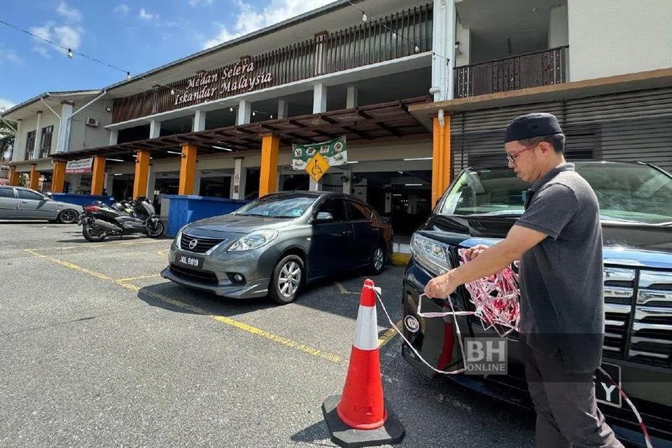 Seorang peniaga, Encik Alif Abdullah, terpaksa meletak kon penghadang berikutan kawasan meletak kereta  awam di situ dimonopoli kenderaan pekerja Malaysia di Singapura sejak dua tahun lalu di Gelang Patah, Johor. 
