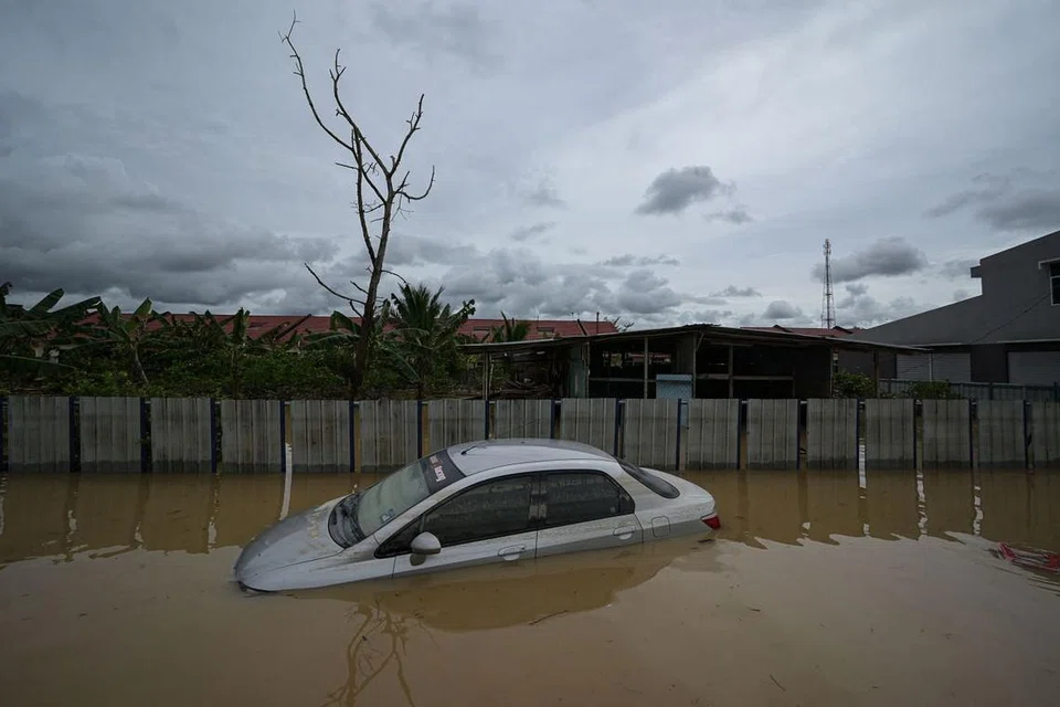 MANGSA BANJIR MENINGKAT: Sebuah kereta tenggelam dalam banjir susulan hujan lebat musim monsun di Kampung Desa Bakti di Pahang, Malaysia semalam. - Foto AFP
