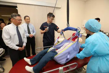 KEMUDAHAN BARU: Encik Gan Kim Yong (kiri) menyaksikan demonstrasi yang ditunjukkan oleh seorang pekerja di pusat baru itu. - Foto CMG