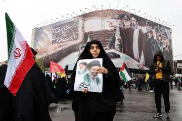 Seorang wanita Iran memegang gambar pemimpin tertinggi baharu Iran, Ayatollah Mojtaba Khamenei, yang dicalonkan selepas bapanya dibunuh dalam serangan Amerika Syarikat dan Israel pada 28 Februari, ketika menyertai perhimpunan Hari Al-Quds (Baitulmakdis), satu acara tahunan menyokong rakyat Palestin yang diadakan pada Jumaat terakhir bulan Ramadan di Teheran pada 13 Mac 2026.
Pada 28 Februari, Israel dan Amerika Syarikat melancarkan serangan ke atas Iran yang mengorbankan pemimpin tertingginya dan mencetuskan perang yang kemudian merebak ke seluruh Asia Barat.