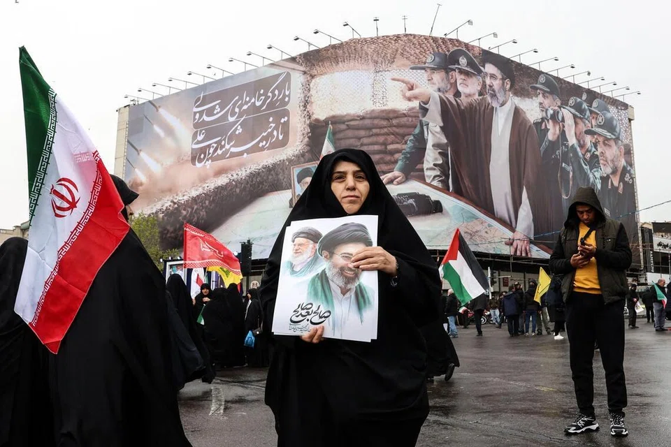 Seorang wanita Iran memegang gambar pemimpin tertinggi baharu Iran, Ayatollah Mojtaba Khamenei, yang dicalonkan selepas bapanya dibunuh dalam serangan Amerika Syarikat dan Israel pada 28 Februari, ketika menyertai perhimpunan Hari Al-Quds (Baitulmakdis), satu acara tahunan menyokong rakyat Palestin yang diadakan pada Jumaat terakhir bulan Ramadan di Teheran pada 13 Mac 2026.
Pada 28 Februari, Israel dan Amerika Syarikat melancarkan serangan ke atas Iran yang mengorbankan pemimpin tertingginya dan mencetuskan perang yang kemudian merebak ke seluruh Asia Barat.