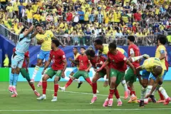 Penjaga gol Maghribi, Yassine Bounou, menyelamatkan bola sambil diasak pemain Brazil, Danilo. 
