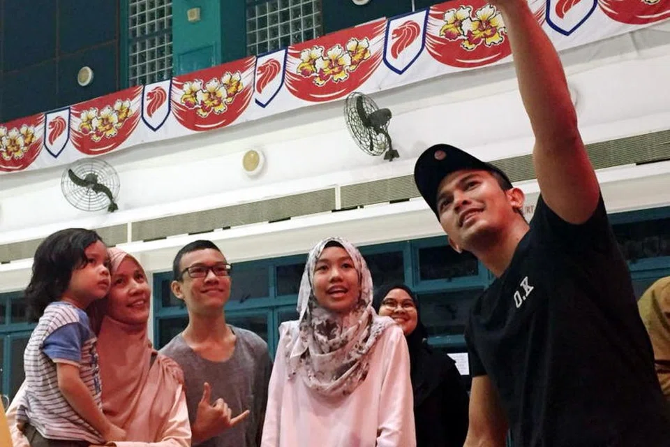 Peminat pelakon dan usahawan Malaysia, Saharul Ridzwan (kanan), datang menyokong perniagaan kuih-muihnya, sewaktu musim Lebaran di Kelab Masyarakat Toa Payoh West pada 2016.