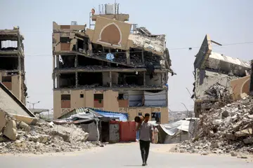 Seorang penduduk Palestin yang kehilangan tempat tinggal berjalan melintasi runtuhan bangunan yang musnah akibat serangan tentera Israel di Khan Younis, selatan Gaza, pada 11 Ogos 2026. Lembaga Keamanan menafikan dakwaan ia mencapai perjanjian untuk membayar hutang Hamas sehingga AS$400 juta ($512 juta), sambil menjelaskan dana itu bertujuan menangani tanggungan sah, termasuk bayaran kepada pembekal dan pampasan kakitangan awam yang tidak diserap ke dalam pentadbiran baharu Gaza.