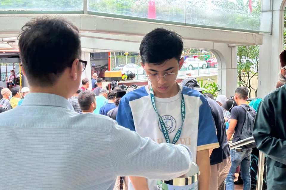 Seorang sukarelawan belia masjid membantu dalam kegiatan pengumpulan dana masjid. Foto dirakam pada 2023.   