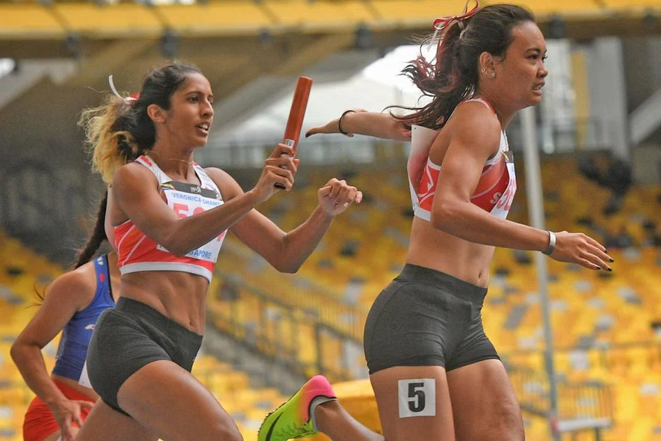 CIPTA REKOD: Shanti Pereira (kiri) memberi baton kepada Nur Izlyn Zaini semasa peringkat akhir acara lari berganti-ganti 4x100m Sukan SEA, di mana mereka dapat mencatat rekod Singapura dengan masa 44.96 saat bersama Wendy Enn dan Dipna Lim Prasad. - Foto fail