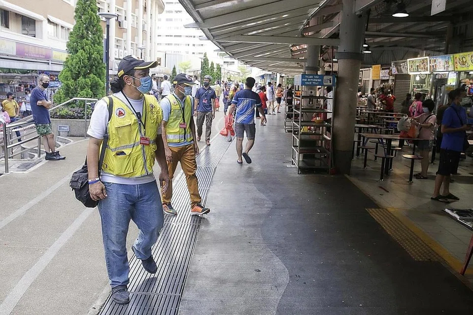 JAGA KEMASLAHATAN MASYARAKAT: Encik Mohamad Umar ialah antara 20 sukarelawan di kawasan Jurong Springs yang menasihati penduduk di situ supaya mengekalkan jarak selamat sementara gambar sisipan pula semasa beliau beristirahat. - Foto BH oleh AZMI ATHNI