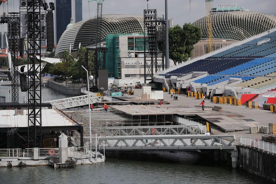 PERSIAPAN SEDANG RANCAK DIBUAT: Para pekerja dilihat mendirikan struktur di platform terapung Marina Bay, semalam. - Foto BH oleh GIN TAY