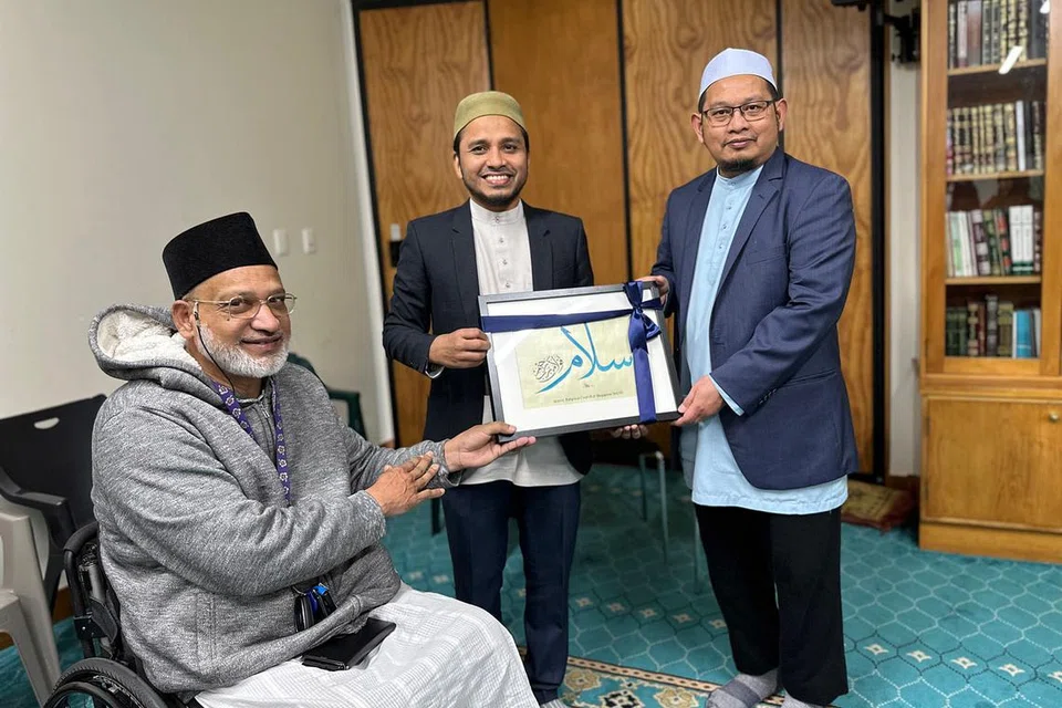 CENDERAHATI: Ustaz Dr Nazirudin (tengah) menyampaikan cenderahati kepada Imam Masjid Al-Noor, Ustaz Mohd Idris Osman (kanan). Bersama mereka ialah Encik Farid Ahmed (berkerusi roda) - isteri beliau terkorban dalam kejadian tembakan di masjid tersebut. - Foto Muis